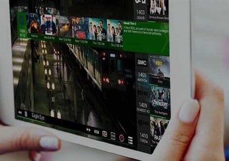 The HDHomeRun app playing live TV on a tablet held in two hands